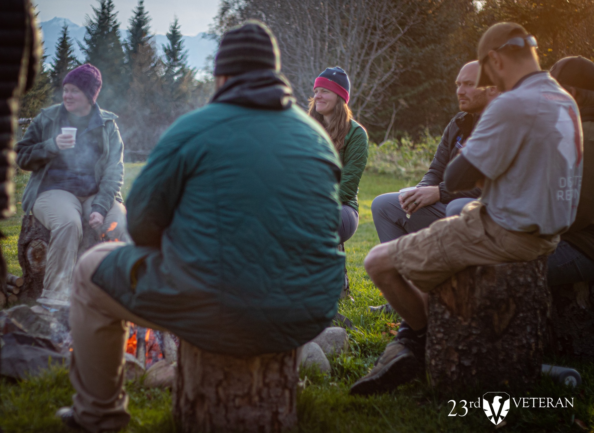 Veterans and retreat participants in conversation around a campfire